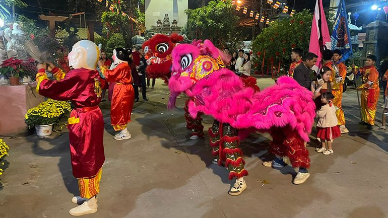 Đội múa lân chùa Phật Tích phục vụ bà con người Việt trong đêm Giao thừa. (Ảnh: Hải Tiến)