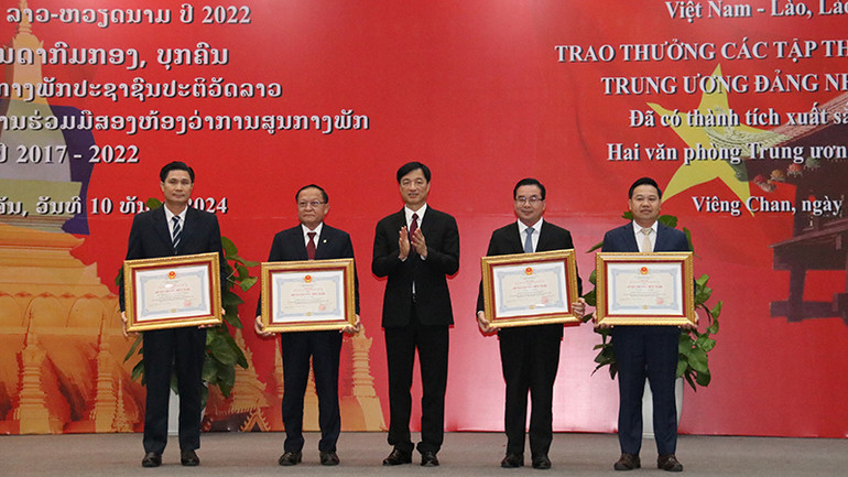 Đồng chí Nguyễn Duy Ngọc trao tặng Huân, Huy chương cho các tập thể, cá nhân của Văn phòng Trung ương Đảng Nhân dân Cách mạng Lào. Ảnh: Hải Tiến