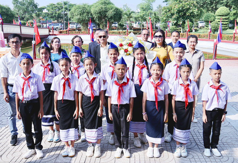 Hội người Việt Nam tỉnh Khammuon và các thầy cô giáo, các em học sinh Trường Thống Nhất Việt Triều-Thà Khẹc dâng hoa bày tỏ lòng thành kính. (ẢNH: TRINH DŨNG)