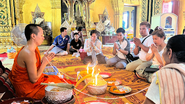Trong dịp Bun Pi May, người dân Lào thường thực hiện nghi lễ buộc chỉ cổ tay tại các ngôi chùa để cầu an cho gia đình trong năm mới.