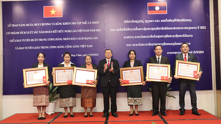 Đồng chí Lại Xuân Môn trao tặng Huân chương của Nhà nước Việt Nam cho các cá nhân thuộc Ban Tuyên huấn Trung ương Đảng Nhân dân Cách mạng Lào. (Ảnh: HẢI TIẾN)
