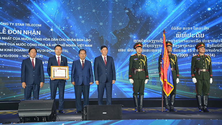 Thừa ủy quyền của Chủ tịch nước Cộng hòa dân chủ nhân dân Lào, Đại tướng Chansamone Chanyalath đã trao Huân chương Lao động hạng Nhất của Lào tặng Unitel. (Ảnh: TRỊNH DŨNG)
