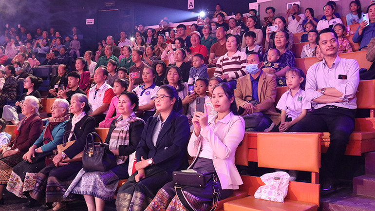 Đông đảo người dân Lào và người Việt Nam sinh sống tại Lào ở mọi lứa tuổi chăm chú thưởng thức chương trình biểu diễn. (Ảnh: Hải Tiến)