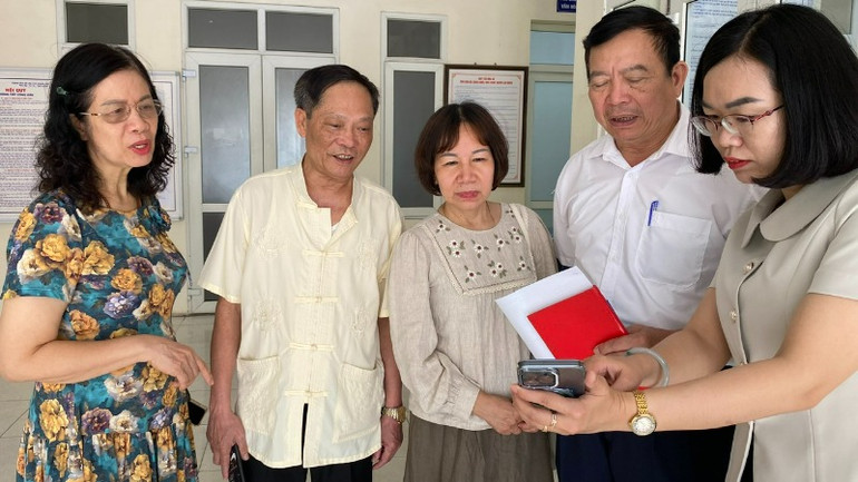 Đồng chí Hà Thị Phương Dung, Phó Chủ tịch Ủy ban nhân dân phường Bưởi trao đổi với người dân về ứng dụng công nghệ số.