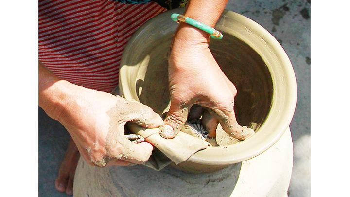 Sau khi tạo hình, gốm được chuốt bằng khăn tăng độ mịn.