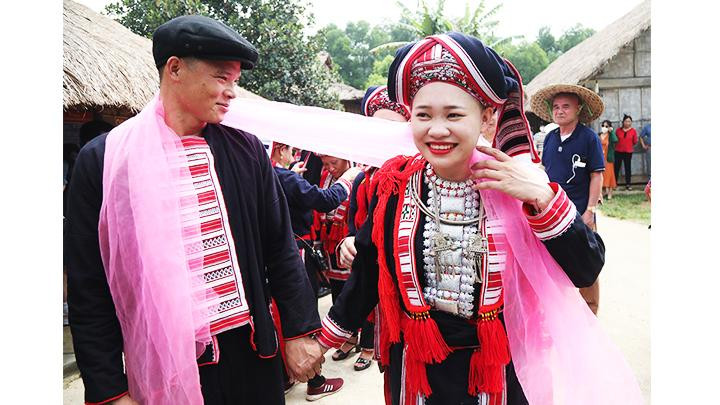 Đôi vợ chồng trẻ buộc dải khăn đỏ thể hiện sợi dây tơ hồng gắn kết hạnh phúc bền lâu. Đôi vợ chồng trẻ buộc dải khăn đỏ thể hiện sợi dây tơ hồng gắn kết hạnh phúc bền lâu.