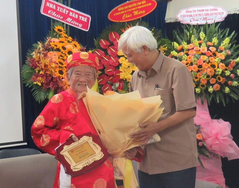 Nhà sử học Dương Trung Quốc (bên phải) trao quà của Hội Khoa học Lịch sử Việt Nam tặng nhà nghiên cứu lịch sử Nguyễn Đình Tư.