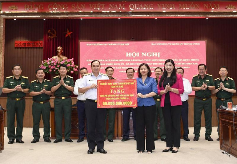 Lãnh đạo thành phố Hà Nội trao tặng kinh phí xây dựng nhà văn hóa đa năng trên huyện đảo Trường Sa cho lãnh đạo Quân chủng Hải quân. (Ảnh: DUY LINH)