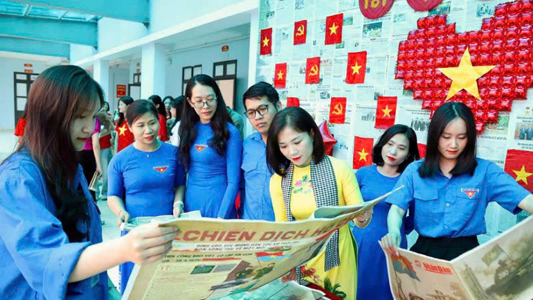 Các cô giáo Trường trung học phổ thông Công nghiệp Hòa Bình chăm chú với phụ san. (Ảnh: NGUYỄN TUẤN)