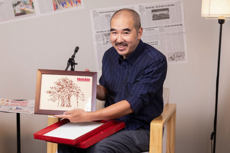 Đạo diễn Bùi Thạc Chuyên nhận món quà là bức tranh ghép của Vụn Art hình cây đa - Hình ảnh biểu tượng của Tòa soạn Báo Nhân Dân.