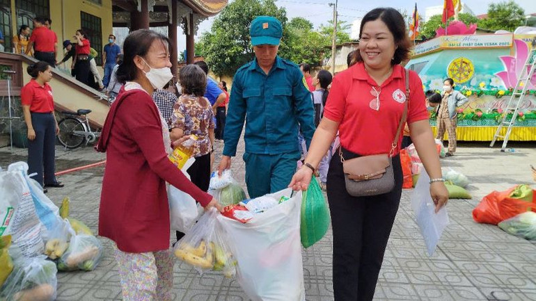 Cán bộ Hội Chữ thập đỏ và lực lượng dân quân giúp vận chuyển hàng hóa từ "Chợ 0 đồng" cho người dân.