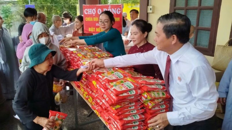 Chủ tịch Hội đồng nhân dân tỉnh Bình Dương Nguyễn Văn Lộc và đại diện các đơn vị trao hàng hóa tại "Chợ 0 đồng" cho người dân có hoàn cảnh khó khăn.