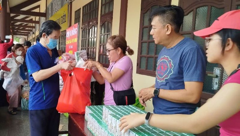 Trao hỗ trợ sữa uống cho người dân tại phiên chợ.