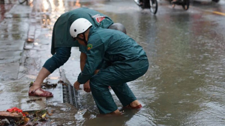 Lực lượng dân quân khơi thông các nắp hố ga để thoát nước. Lực lượng dân quân khơi thông các nắp hố ga để thoát nước.