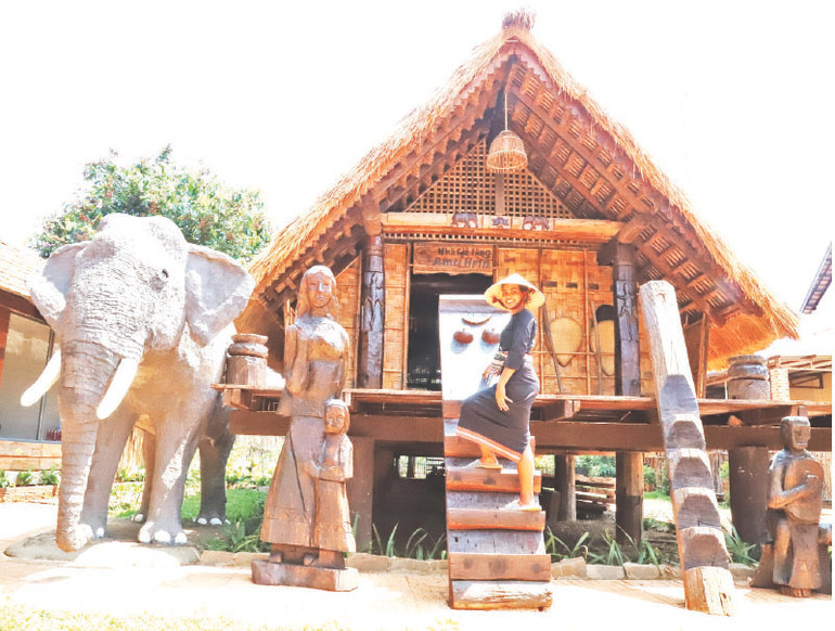 Khi đứng bên nhà sàn dài truyền thống càng tôn thêm vẻ đẹp của người phụ nữ Ê Đê.