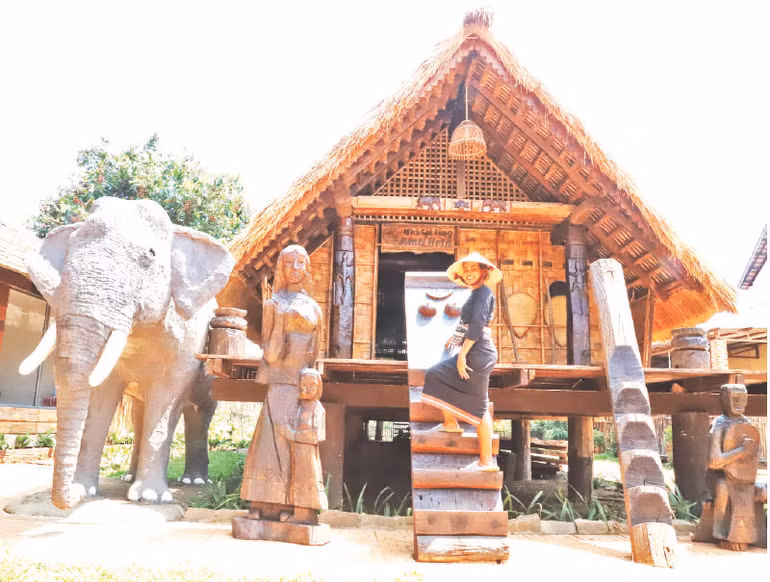 Khi đứng bên nhà sàn dài truyền thống càng tôn thêm vẻ đẹp của người phụ nữ Ê Đê.