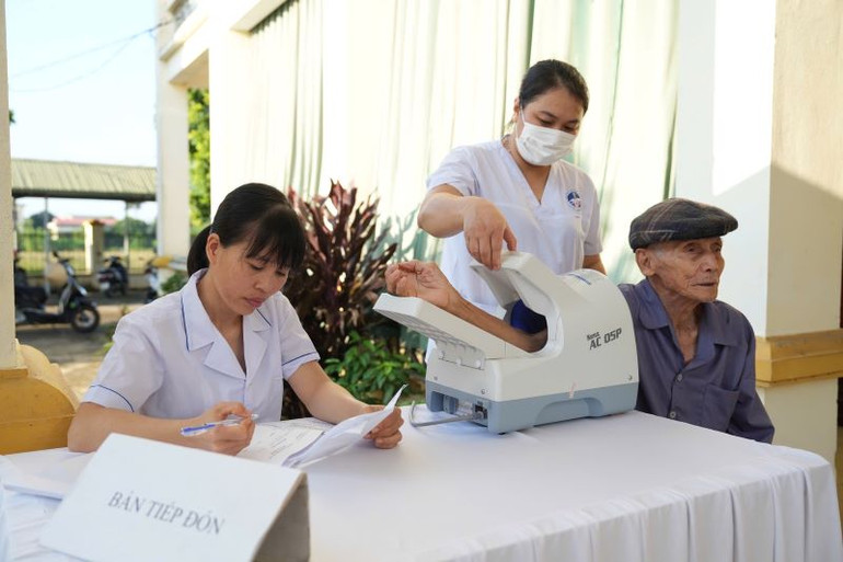 Các y, bác sĩ Cảnh sát biển khám bệnh cho nhân dân bằng trang thiết bị hiện đại.