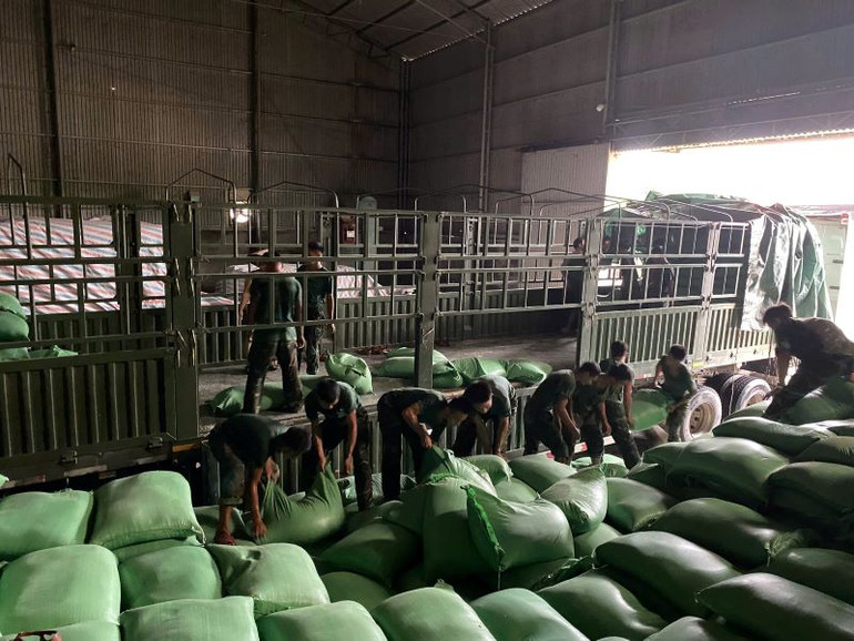 Cán bộ, chiến sĩ Trung đoàn 101, Sư đoàn 325 giúp địa phương vận chuyển 130 tấn gạo tại kho gạo xã Nghĩa Hồ, huyện Lục Ngạn, tỉnh Bắc Giang đến nơi an toàn.