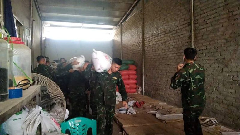 Cán bộ, chiến sĩ Trung đoàn 95, Sư đoàn 325 giúp gia đình chị Nông Thị Thu, thôn Bồng, xã Than Hải, huyện Lục Ngạn, tỉnh Bắc Giang, chuyển 20 tấn thóc, gạo đến nơi an toàn.