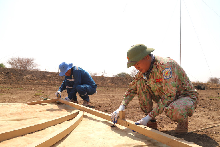 Cán bộ, nhân viên Đội Công binh Việt Nam lắp ghép, bố trí lều bạt bảo đảm nơi ăn, chốn ở để chuẩn bị thi công xây dựng doanh trại cho Tiểu đoàn Bộ binh Ghana. (Ảnh: Đội Công binh Việt Nam cung cấp).