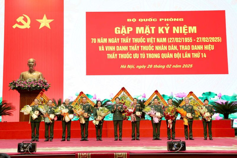 Đại tướng Phan Văn Giang tặng hoa và kỷ niệm chương vinh danh các Thầy thuốc Nhân dân trong quân đội.