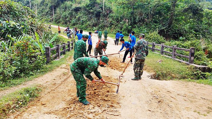 Cán bộ, chiến sĩ Đồn Biên phòng Ba Nang phối hợp Đoàn Thanh niên thôn Sa Trầm cải tạo đường giao thông ở xã biên giới.