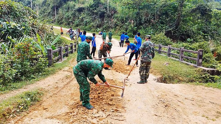Cán bộ, chiến sĩ Đồn Biên phòng Ba Nang phối hợp Đoàn Thanh niên thôn Sa Trầm cải tạo đường giao thông ở xã biên giới.