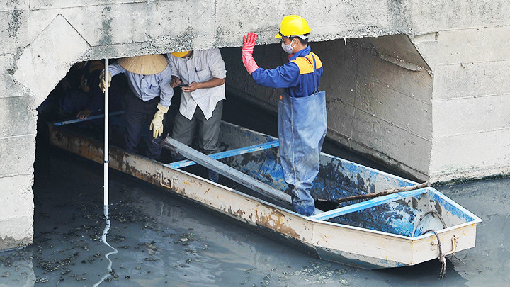 Công nhân Công ty thoát nước Hà Nội kiểm tra hệ thống cống ngầm. Ảnh: NAM HẢI