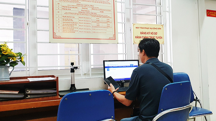 Người dân nộp hồ sơ trực tuyến tại ủy ban phường. Ảnh: SONG ANH