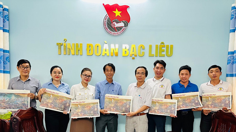 Đồng chí Trần Nguyễn Trường Giang (thứ tư từ trái sang), Phó Bí thư Tỉnh đoàn Bạc Liêu đón nhận tranh của Báo Nhân Dân.