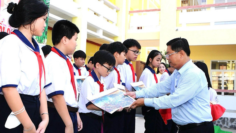 Thầy giáo Trần Bằng Phi, Trưởng Phòng Giáo dục và Đào tạo thành phố Bạc Liêu trao tặng tranh &quot;Chiến thắng Điện Biên Phủ&quot; cho những em học sinh xuất sắc, năm học 2023-2024.