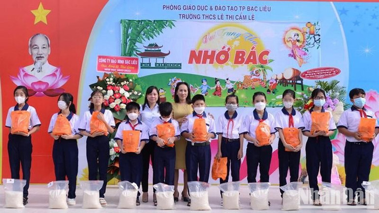 Cô Trần Kim Thi, Hiệu trưởng Trường trung học cơ sở Lê Thị Cẩm Lệ (thành phố Bạc Liêu) trao quà, gạo những học sinh có hoàn cảnh khó khăn của trường. (Ảnh TRỌNG DUY)