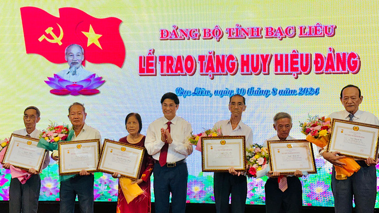 Đồng chí Tạ Trung Dũng, Trưởng ban Tuyên giáo Tỉnh ủy, trao Huy hiệu đảng cho các đảng viên cao niên tuổi đảng. Ảnh: TD