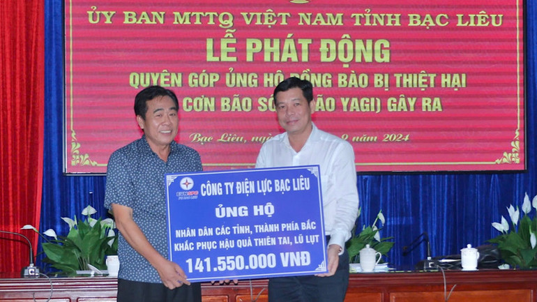 Giám đốc Công ty Điện lực Bạc Liêu Trần Hữu Khoa (bên trái) trao số tiền ủng hộ hơn 141 triệu đồng.