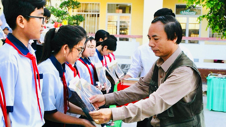 Nhà báo Trọng Duy, Trưởng Văn phòng đại diện Báo Nhân Dân tại Bạc Liêu trao tặng tranh cho các em học sinh Bạc Liêu.