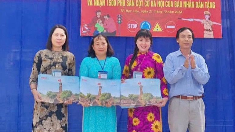 Nhà báo Trọng Duy, đại diện Báo Nhân Dân tại Bạc Liêu trao tặng ấn phẩm phụ san Cột cờ Hà Nội cho Ban lãnh đạo Trường Tiểu học Phùng Ngọc Liêm (thành phố Bạc Liêu).