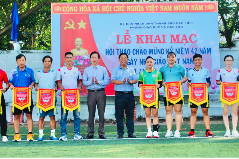 Đồng chí Trần Bằng Phi, Trưởng Phòng Giáo dục và Đào tạo thành phố Bạc Liêu (tỉnh Bạc Liêu) trao tặng cờ cho các đơn vị có thành tích xuất sắc tại hội thao chào mừng kỷ niệm 42 năm Ngày Nhà giáo Việt Nam.