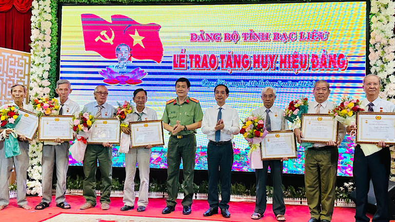 Thay mặt Ban Thường vụ Tỉnh ủy, đồng chí Hồ Thanh Thủy, Trưởng ban Tổ chức Tỉnh ủy và Đại tá Hồ Việt Triều, Giám đốc Công an tỉnh Bạc Liêu, trao Huy hiệu các đảng viên cao niên tuổi đảng.