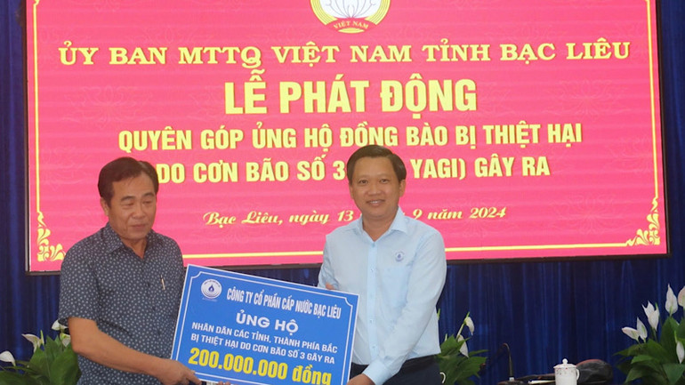 Giám đốc Công ty cổ phần Cấp nước Bạc Liêu Võ Minh Trang (bên trái) trao số tiền ủng hộ 200 triệu đồng