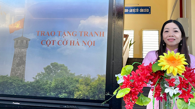 Cô Đinh Dung, giáo viên Trường trung học cơ sở Lê Thị Cẩm Lệ (thành phố Bạc Liêu) giới thiệu ý nghĩa ấn phẩm phụ san Cột cờ Hà Nội do Báo Nhân Dân thực hiện và trao tặng cho các thầy cô, các em học sinh của trường.