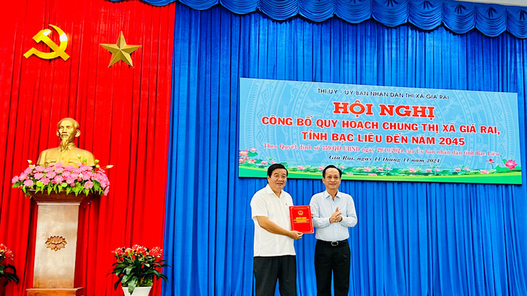 Chủ tịch Ủy ban nhân dân tỉnh Bạc Liêu Phạm Văn Thiều trao quyết định công bố quy hoạch chung thị xã Giá Rai cho Chủ tịch Ủy ban thị xã Giá Rai Đỗ Minh Thắng. Ảnh: TRỌNG DUY