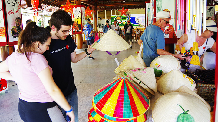 Mua quà lưu niệm nón lá Việt Nam.