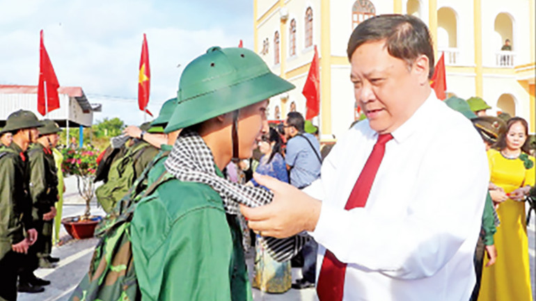 Lãnh đạo Ủy ban nhân dân tỉnh Cà Mau choàng khăn, tặng hoa chúc mừng tân binh lên đường nhập ngũ.