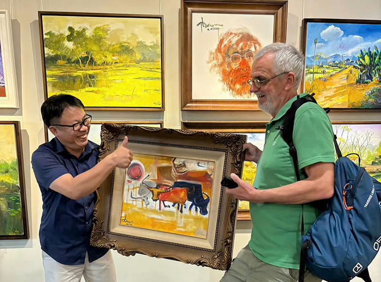 Khách nước ngoài mua tranh của họa sĩ.