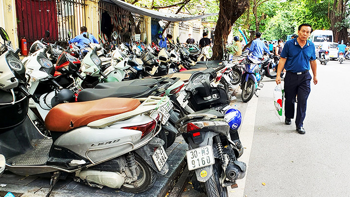 Người dân phải đi bộ dưới lòng đường do vỉa hè hết chỗ trống tại phố Phủ Doãn.