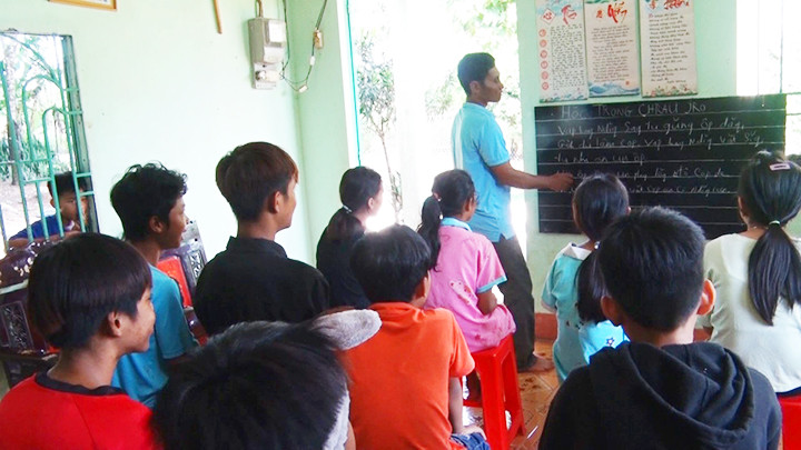 Anh Điểu Toa dạy tiếng dân tộc cho các em thiếu nhi. Ảnh: QUANG HOÀNG