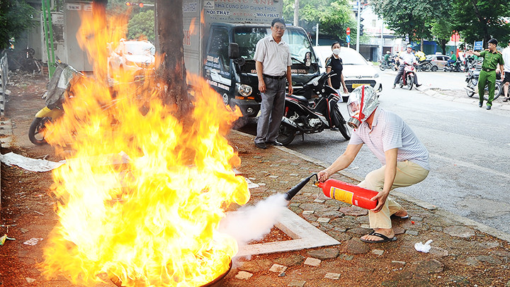 Người dân tập dập lửa bằng bình chữa cháy.