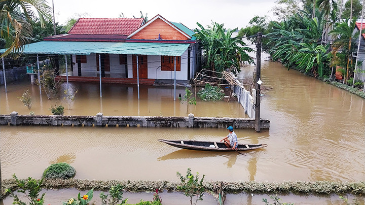 Người dân vùng hạ du sông Bồ đi lại bằng ghe khi nước lũ ngập sâu.