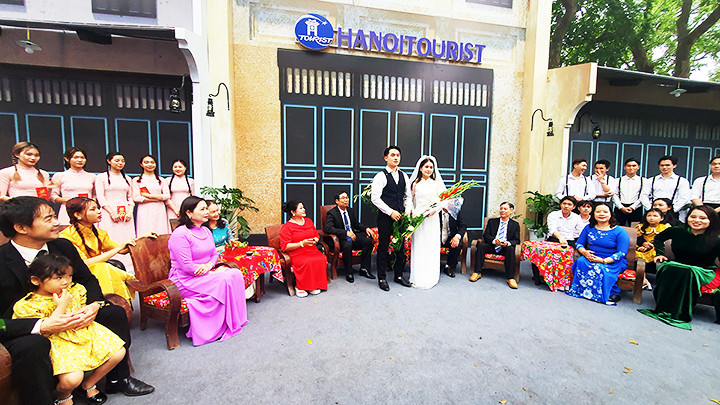 Cô dâu trong trang phục cưới với khăn voan, ôm bó hoa lay-ơn cùng chú rể ra mắt hai họ.