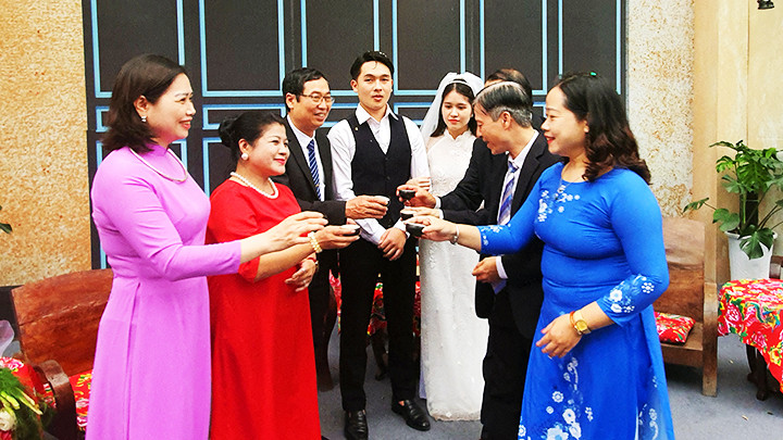 Gia đình hai bên chúc phúc cho đôi trẻ trong ngày cưới.